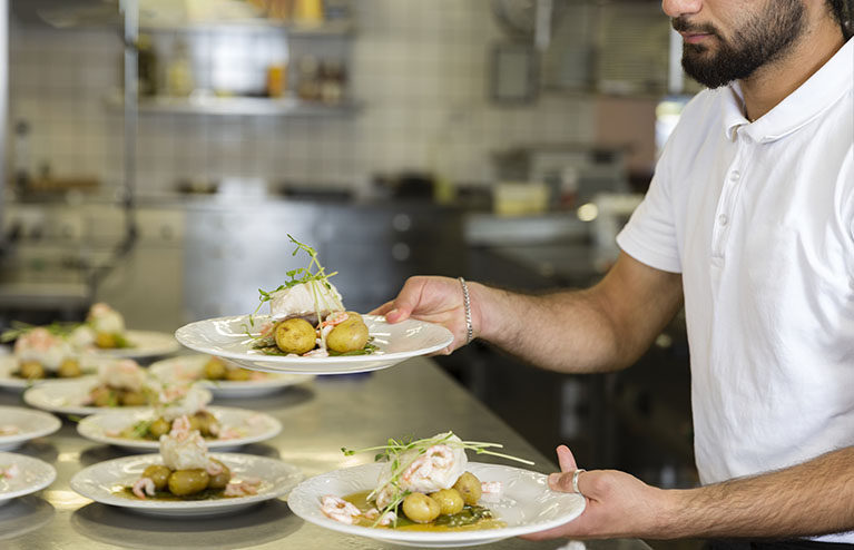 Mat på tallrikar i restaurangkök