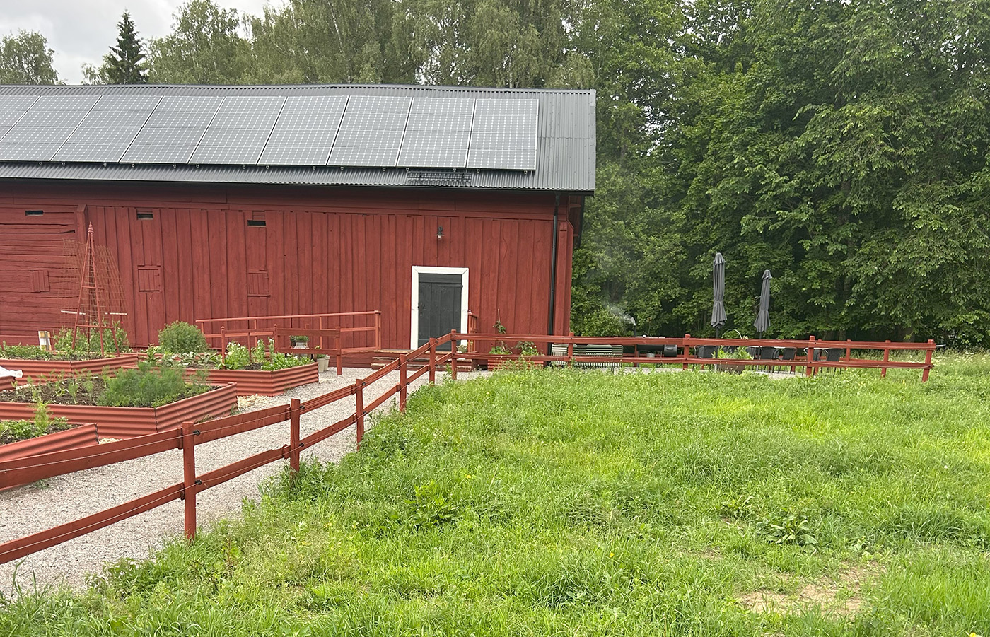 Flera odlingslådor framför en lada